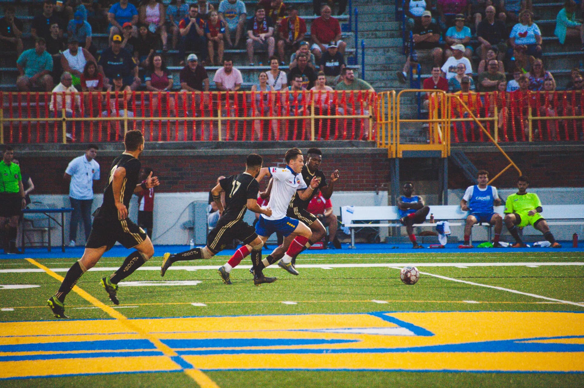 Hacha driving at goal with the ball while opponents give chase