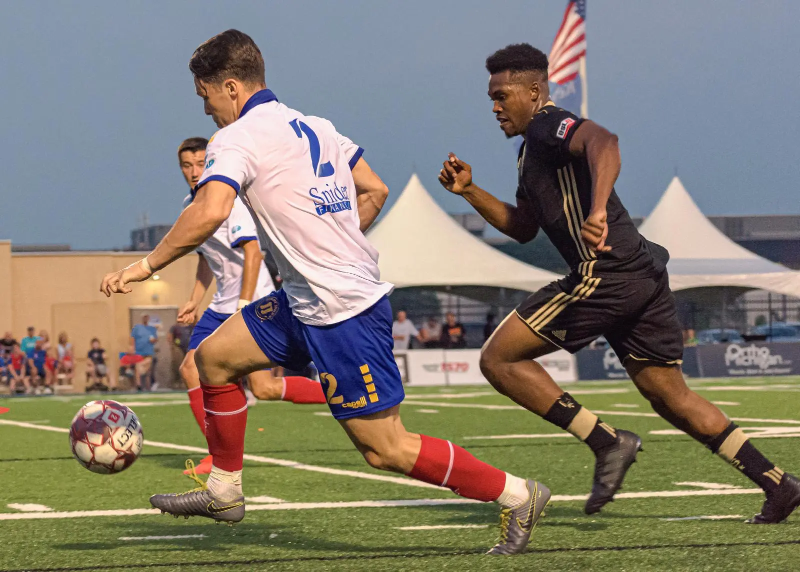 Hacha challenging an opponent for the ball during a football match