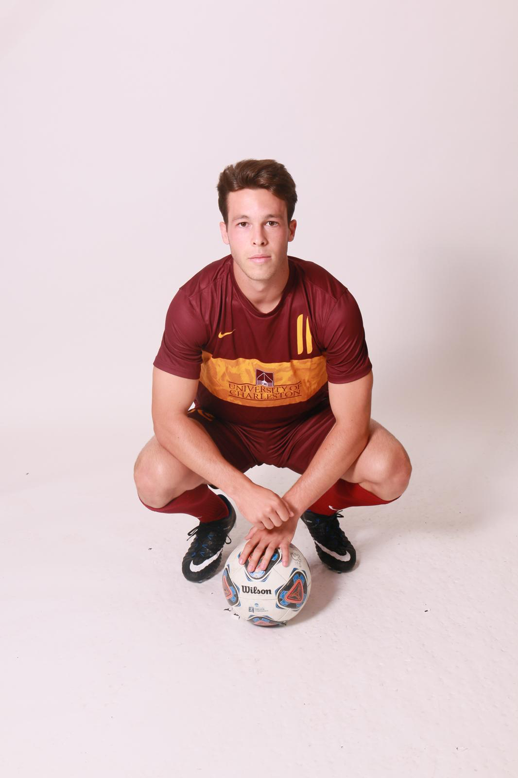 Hacha during his football career, crouched over a football